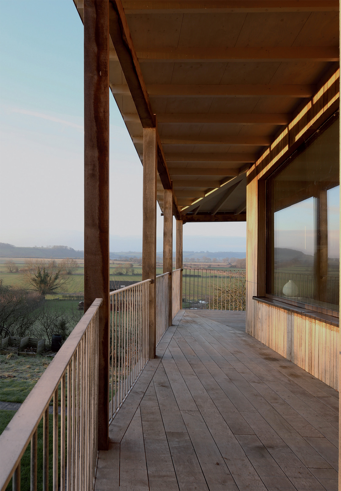 The exterior is clad in green oak and there’s an outrigger structure of green oak posts, with this outer structure providing solar shading to the windows