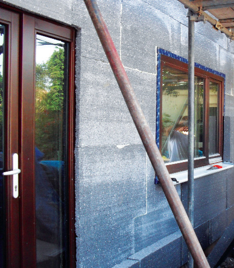 External wall insulation showing door overlapped by first layer and second layer being installed