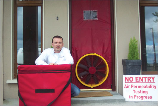 Pat Kyne of PK Energy Controls next to a blower-door