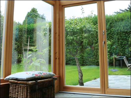 Looking out onto the garden from the sunroom, with slate floor for thermal mass and heat absorption, and solar shading on the roof to prevent overheating