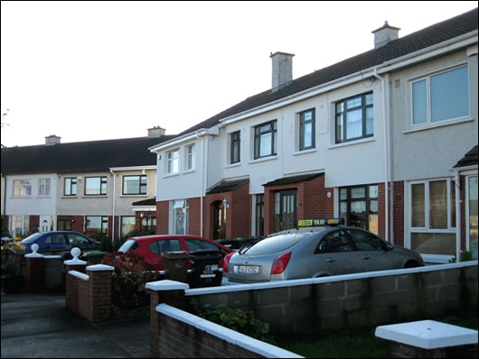 A terrace in North Dublin (below) where three householders externally insulated with a brick-like render finish (above) to base and a napp finish render